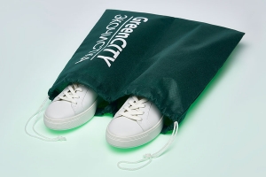 Мешок для обуви из зеленого спанбонда с белым шнуром и логотипом белого цвета.