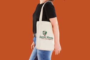Эко сумка шоппер из двунитки суровой естественного цвета с логотипом зеленого и коричневого цветов, длинные ручки удобны для ношения сумки на плече.
