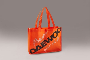 Обьмная промо сумка шоппер с логотипом черного и белого цветов из оранжевого спанбонда.