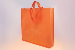 Обьемная промо сумка из оранжевого спанбонда с четырьмя ручками, две короткие ручки  и две длинные для ношения на плече.