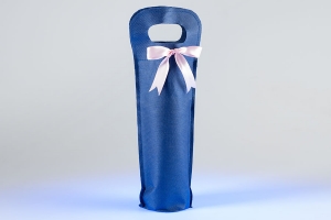 Промо сумка для бутылки с вырубными ручками украшенная бантом из розовой атласной ленты, сшита из синего спанбонда.