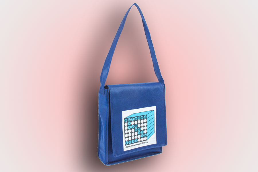 эко сумка с клапаном и длинной ручкой через плечо из синего спанбонда, на клапане нанесен логотип методом шелкографии